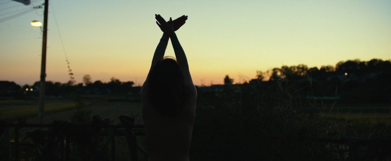 Still from the 2018 film "Burning" in which a woman is silhouetted before a sunset.