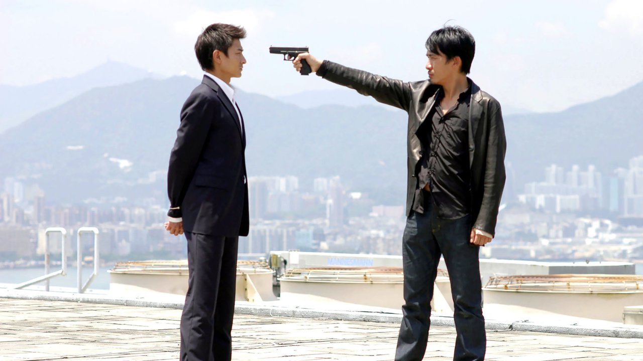 Two characters on top of a building, one at gunpoint, in a crucial scene in "Infernal Affairs".