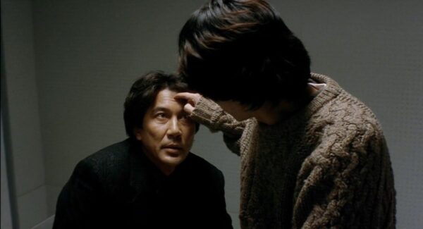 Scene in which detective Takabe is being interrogated by the suspect Mamiya, from the 1997 Kiyoshi Kurasawa film "Cure"