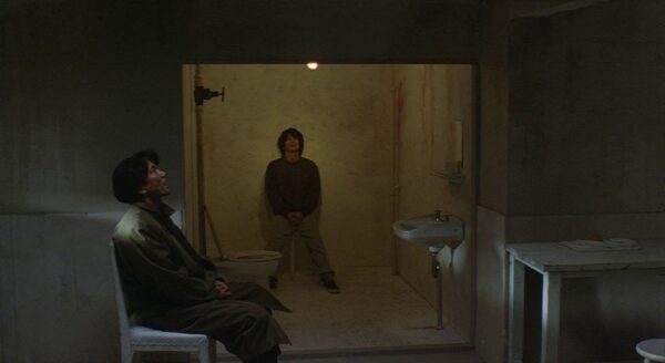 Scene with Takabe confronting Mamiya in his cell, from the 1997 Kiyoshi Kurasawa film "Cure"