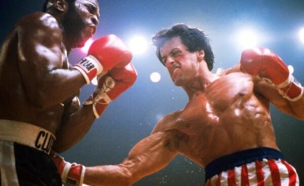 Still from Rocky III (1982) with main characters in the ring.